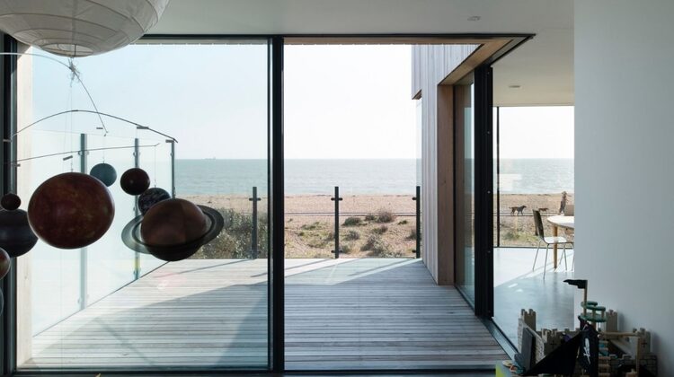 corner opening sliding glass doors leading to a seafront decking in a luxury coastal home