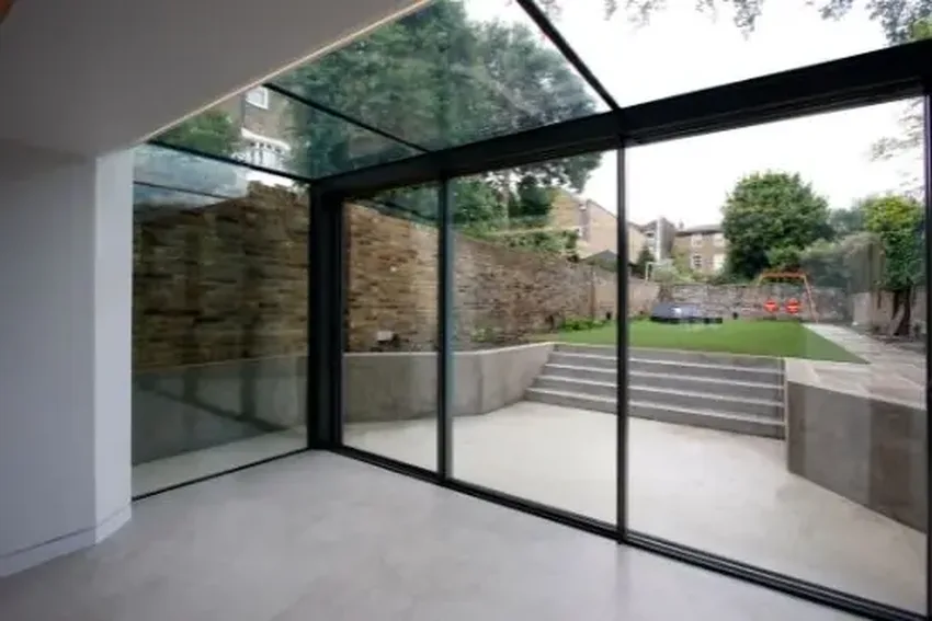 glass box extension using a three pane minimal windows sliding glass patio door and structural roof glazing