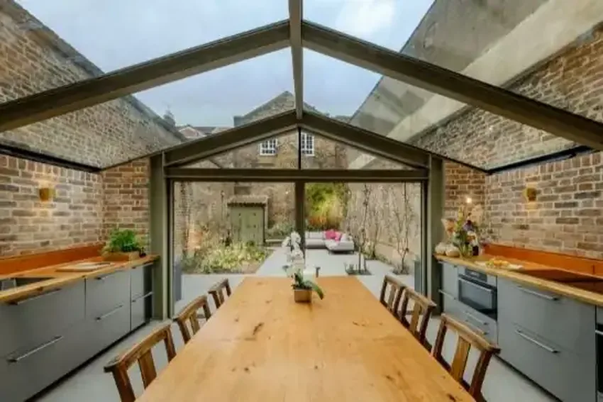 glass extension using double opening minimal windows pivot doors and a structural roof glazing with a steel support structure