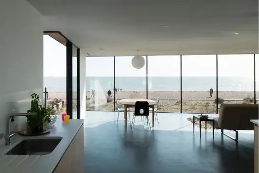 minimal windows open corner sliding doors and structural glazing with solar control glass in a new build luxury coastal home
