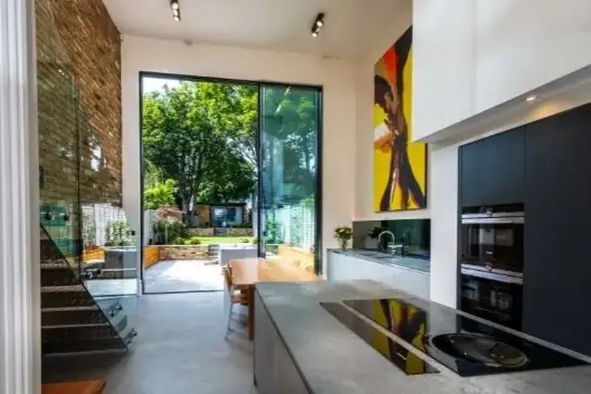modern double height kitchen and diner area with luxury interior design and oversized sliding glass doors to create a striking glazing elevation