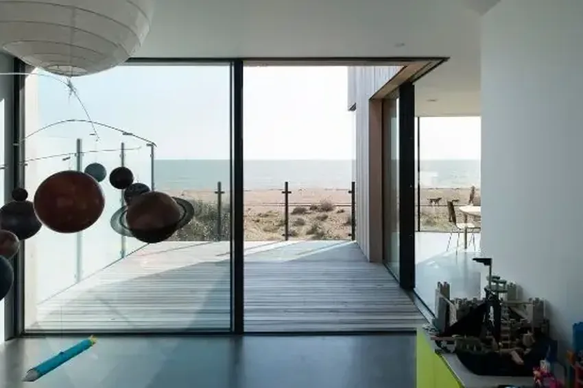 open corner minimal windows sliding glass doors on a beachfront luxury home